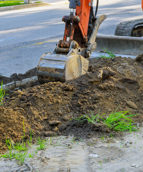 A bulldozer digging dirt in the middle of a street