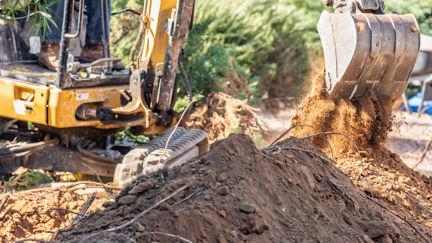 A bulldozer digging a pile of dirt